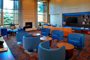a waiting room with blue chairs and a fireplace at Sonesta Select Chicago Elgin West Dundee in Elgin