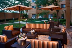patio z kanapami, stołami i parasolami w obiekcie Sonesta Select Chicago Elgin West Dundee w mieście Elgin