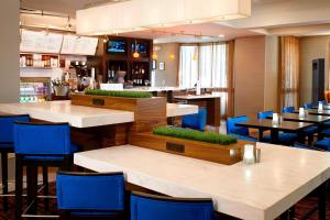 Sonesta Select Chicago Elgin West Dundee في إلجين: مطعم بطاولات بيضاء وكراسي زرقاء