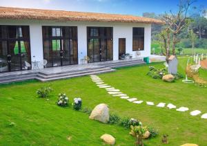 a house with a green lawn and a house with a garden at Eagle Bavi Resort in Ba Vì