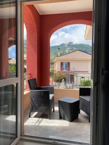 特羅佩阿的住宿－Aether Suites Tropea - Free Parking，阳台享有桌椅的景色