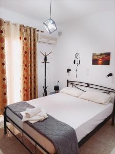 una camera con un grande letto bianco di Ιno Skiathos a Città di Skiathos
