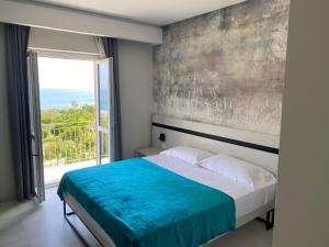 ein Schlafzimmer mit einem Bett und einem großen Fenster in der Unterkunft Aether Suites Tropea - Free Parking in Tropea