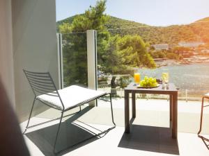a table and chairs on a balcony with a view at Hotel Kompas in Dubrovnik