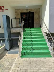 una scala con gradini verdi di fronte a un edificio di Toto’s Apartment a Constanţa