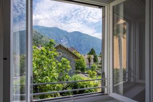 a window with a view of a mountain at Residenza La Serenata - Happy Rentals in Cavigliano