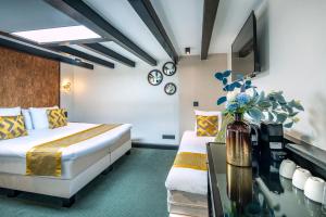 um quarto de hotel com duas camas e uma mesa de vidro em Sotel Amsterdam Central Station em Amsterdã