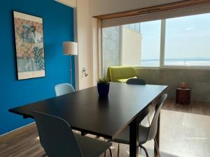 une salle à manger avec une table et des chaises noires dans l'établissement Cacilhas Amazing view of Lisbon close to beach Caparica, à Almada