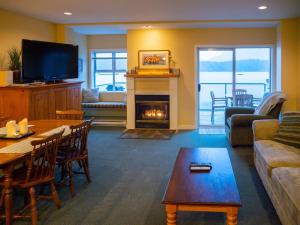 a living room with a table and a fireplace at Waterfront View of the Inlet, Short Walk to Town in Tofino