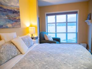 a bedroom with a large bed and a window at Waterfront View of the Inlet, Short Walk to Town in Tofino