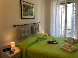 una camera da letto con un letto verde con due asciugamani di Casa di Max by Holiday World a Torino