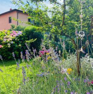 a garden with colorful flowers and a building at Lakes&Hills Apartments in Erba