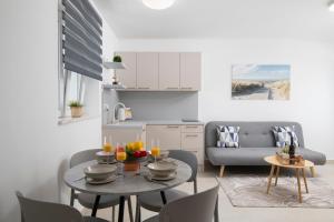 a kitchen and living room with a table and a couch at Apartments and rooms Jakić in Medulin