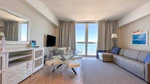 a living room with a glass table and a couch at Residence Lungomare - Charming apartments in Riccione
