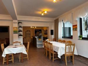 comedor con 2 mesas y sillas y cocina en agriturismo La via del sale2, en Pignone