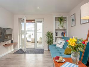 Riverside Apartment في بيدفورد: غرفة معيشة مع أريكة زرقاء وطاولة