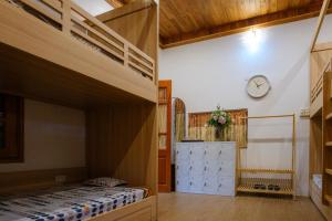 sypialnia z 2 łóżkami piętrowymi i zegarem na ścianie w obiekcie Bavi Homestead w mieście Ba Vì District