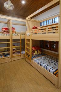2 łóżka piętrowe w pokoju z drewnianymi ścianami w obiekcie Bavi Homestead w mieście Ba Vì District