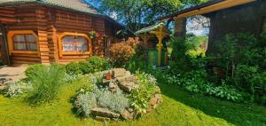 um jardim em frente a um chalé de madeira em Прутець em Mykulychyn