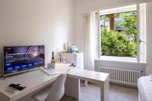 una scrivania bianca con computer e finestra di Residenza La Serenata - Happy Rentals a Cavigliano