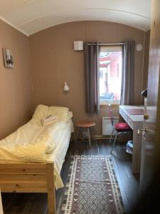 a bedroom with a bed and a desk and a window at Fjordutsikten Motell & Camping AS in Lakselv