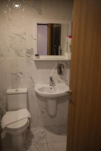 a white bathroom with a toilet and a sink at Cinas Hotel in Eskisehir