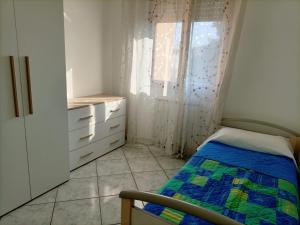 Habitación pequeña con cama y ventana en Appartamento Verde Salvia, en Pescara