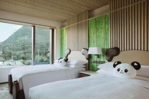 a bedroom with two beds with stuffed pandas on them at Hong Kong Ocean Park Marriott Hotel in Hong Kong