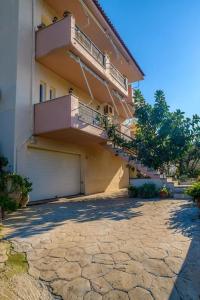 een groot gebouw met een garage en een balkon bij “Shiny” sea view apartment at Istron in Agios Nikolaos