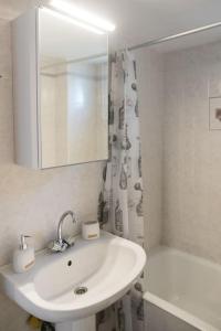 een badkamer met een wastafel, een spiegel en een bad bij “Shiny” sea view apartment at Istron in Agios Nikolaos