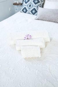 アギオス・ニコラオスにある“Shiny” sea view apartment at Istronの白いベッドに白いタオル2枚(花付)