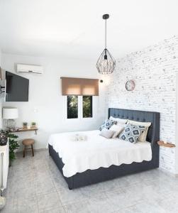 een slaapkamer met een groot bed en een bakstenen muur bij “Shiny” sea view apartment at Istron in Agios Nikolaos
