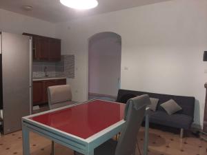 uma sala de estar com uma mesa vermelha e um sofá em Trilocale Serra Li Lioni - Sassari em Sassari