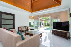 a living room with a large flat screen tv at Balinese Style 3BR Villa Morning Forest, Nai Harn in Rawai Beach