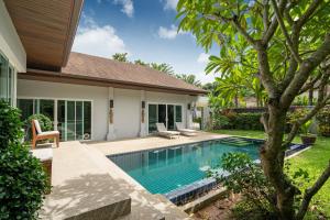 a swimming pool in the backyard of a house at Balinese Style 3BR Villa Morning Forest, Nai Harn in Rawai Beach