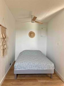a bedroom with a bed and a ceiling fan at T2 rénové avec place parking privée et vue dégagée à Carnon in Carnon-Plage