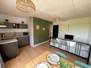 a living room with a bed and a kitchen at T2 rénové avec place parking privée et vue dégagée à Carnon in Carnon-Plage