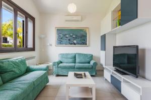 a living room with a couch and a tv at Casa Isola con Giardino by Wonderful Italy in Siracusa