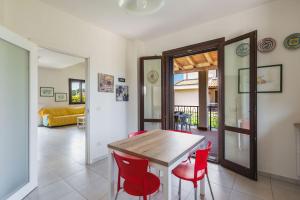 a dining room with a wooden table and red chairs at Casa Isola con Giardino by Wonderful Italy in Siracusa