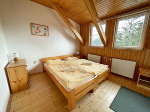 sypialnia z łóżkiem w drewnianym pokoju w obiekcie Horský Hotel Totem w mieście Jarabá