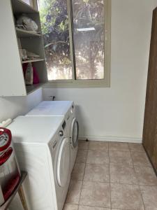 a washing machine in a kitchen with a window at Nazarena Studio Apartment in Nazareth
