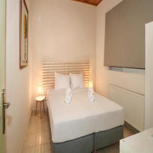 a bedroom with a bed with two candles on it at Family beach house near airport in Artemida