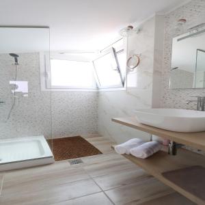 a white bathroom with a tub and a sink at Family beach house near airport in Artemida