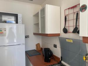 eine Küche mit einem weißen Kühlschrank und einer Theke in der Unterkunft Departamento dos dormitorios nuevo in Curicó