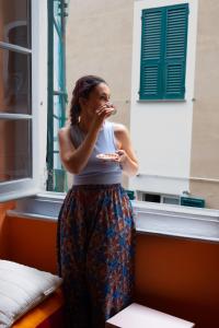 Una donna che mangia cibo davanti a una finestra di Manena Hostel Genova a Genova