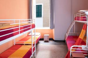 a room with two bunk beds and a window at Manena Hostel Genova in Genova