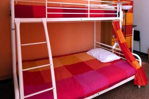 ジェノヴァにあるManena Hostel Genovaの二段ベッド(はしご、カラフルな毛布付)