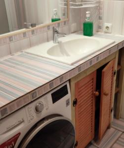 um lavatório e uma máquina de lavar roupa na casa de banho em Grafovi apartments em Narva