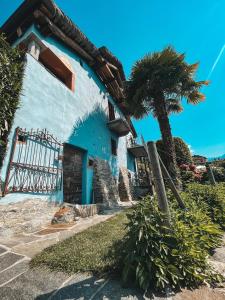 a blue building with a palm tree in front of it at Case di Sotto, House & Breakfast in Locarno