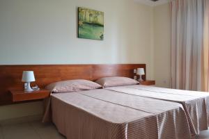 a bedroom with a large bed with a wooden headboard at Apartamentos Garden Atlantis en Club Atlantis in Adeje +49 photos